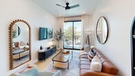 This thoughtfully designed one-bedroom, one-bathroom unit in Phoenix, AZ offers a clean, modern aesthetic throughout its efficiently utilized single-floor layout. The open-concept kitchen and living area serves as the heart of the home, anchored by a sleek white quartz waterfall island with an undermount sink and bar seating — ideal for casual dining or entertaining. The kitchen features light wood cabinetry, a mosaic tile backsplash, stainless steel appliances, and pendant lighting that adds a contemporary touch. Light-toned hardwood flooring flows throughout the main living space, enhancing the bright, airy atmosphere created by white walls and recessed lighting. The living room is generously proportioned, with a sliding glass door that opens to a private balcony, inviting abundant natural light and views of the surrounding neighborhood. A ceiling fan adds comfort to the space. The bedroom offers a quiet retreat with a large window framing outdoor greenery, a ceiling fan, and clean white walls. The full bathroom is finished with warm wood-toned flooring, a modern vanity with a white countertop, and a full tub-shower combination. Clean lines, neutral tones, and contemporary finishes throughout give this unit a polished, move-in-ready appeal.
