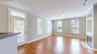 Located at 105 King Farm Blvd in Rockville, MD, this two-story, two-bedroom, two-bathroom home offers a well-designed layout spread across two floors. The main level features a bright and open kitchen and living area, finished with warm hardwood flooring, crown molding, and a ceiling fan. The living room is a standout space, highlighted by a tile-surround fireplace, a built-in display niche, track lighting, and multiple large windows that flood the room with natural light and views of the surrounding greenery. The kitchen is equipped with light wood cabinetry, dark countertops, and black appliances, including a full-size refrigerator, alongside stone-look tile flooring and a sunny window. A convenient attached garage with an automatic opener provides secure parking and additional storage. The upper level hosts two carpeted bedrooms, each with ceiling fans and generous natural light. The primary bedroom connects directly to its own bathroom, which features warm wood vanity cabinetry. A dedicated in-unit laundry room with full-size washer and dryer adds everyday convenience. Two full bathrooms and hallways complete the upper floor. Throughout the home, neutral tones, crown molding, and consistent finishes create a cohesive and comfortable living environment.