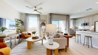 Located on East Camelback Road in Phoenix, this one-bedroom, two-bathroom residence offers a well-designed open-concept layout that maximizes both functionality and natural light. The living room is a standout space, featuring large floor-to-ceiling windows and a sliding glass door that frame expansive city views, flooding the interior with sunlight. A ceiling fan adds comfort, while light hardwood flooring runs throughout the main living areas, creating a warm, cohesive aesthetic.

The kitchen flows seamlessly from the living area and is outfitted with grey shaker-style cabinetry, stainless steel appliances, a white quartz waterfall-edge island with bar seating, and recessed lighting. A sliding door provides balcony access, enhancing the sense of openness.

The bedroom is carpeted and generously sized, featuring a large window with city views, a ceiling fan, and direct access to both a walk-in closet and an en-suite bathroom. The bathrooms include grey cabinetry, LED-backlit mirrors, and hardwood-style flooring. A second closet and a dedicated in-unit laundry room with full-size washer and dryer round out the practical amenities of this thoughtfully appointed residence.