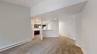 Located at 3075 Woodland Hills Dr in Colorado Springs, CO, this single-floor residence offers a well-designed open layout that connects the living, dining, and kitchen areas seamlessly. The living room is a standout space, featuring soaring vaulted ceilings that enhance the sense of openness, plush carpeting, and a classic white-mantled fireplace with tile surround — a welcoming focal point for the room. A breakfast bar peninsula bridges the living area to the kitchen, which is outfitted with rich dark wood cabinetry, white quartz-style countertops, wood-look vinyl flooring, and white appliances including a range, microwave, refrigerator, and dishwasher. The bedrooms are carpeted and bathed in natural light from large windows and a sliding glass door that opens to a private balcony overlooking mature trees. Closet space is well provided throughout. The bathrooms are clean and functional, featuring a full tub-shower with white tile surround, and a vanity with a marble-style countertop and dark wood cabinetry. Baseboard heating is present throughout the home. The neutral color palette and thoughtful layout make this a comfortable and practical Colorado Springs residence.