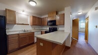 Located at 1945 N 39th St in Milwaukee, Wisconsin, this three-floor property offers a well-organized layout across its main living level, upper floor, and unfinished basement. The kitchen serves as a central feature of the main floor, equipped with warm medium-toned wood cabinetry extending to the ceiling for ample storage, light speckled countertops, and black appliances including an electric range, over-the-range microwave, and dishwasher. A peninsula island provides additional prep space and separates the kitchen from the adjoining area. Wood-look flooring runs throughout the main level, contributing to a cohesive, easy-to-maintain finish.

The upper floor houses carpeted bedrooms, each benefiting from multiple windows that invite natural light and neighborhood views. One bedroom features a wide walk-in closet with wire shelving, offering generous storage capacity. A bathroom on this level includes a wood-vanity with a wide mirror, overhead lighting, and grab bars for accessibility, with wood-look flooring underfoot.

The basement level is fully unfinished, featuring concrete walls, an exposed wood-beam ceiling, and a concrete floor. Laundry hookups are present, and the open layout provides substantial potential for storage or future finishing.