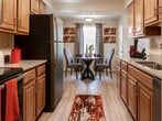 Located at 10 Treeway Ct, Unit 2B in Towson, MD, this single-floor apartment offers 1,340 square feet of living space across four bedrooms, two bathrooms, a living room, and a kitchen. The unit features consistent wood-style laminate flooring throughout, set against neutral, light-toned walls that create a bright and clean atmosphere. The spacious living room is highlighted by large sliding glass doors that invite abundant natural light and provide outdoor views. The kitchen is equipped with warm wood cabinetry, granite-style countertops, a stainless steel dishwasher, and a full-size refrigerator, with an adjacent dining or flex area. The four bedrooms are well-proportioned, with the primary bedroom spanning 230 square feet; several bedrooms feature windows with natural light and dedicated closet space. Three closets are distributed throughout the unit for ample storage. The two bathrooms feature tile flooring and wood vanity cabinetry with white countertops; one includes a walk-in shower with sliding glass doors, while the other offers a shower-tub combination. The layout is functional and efficiently organized across a single level.