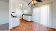 Located at 6141 Orange Ave in Cypress, CA, this single-floor, 2-bedroom, 1-bathroom residence offers a practical and comfortable layout. The open living area features plush wall-to-wall carpeting and flows into a dining space highlighted by a ceiling fan and a sliding glass door that invites natural light and outdoor access. The kitchen is well-equipped with white cabinetry featuring crown molding detail, granite-style countertops, stainless steel appliances including a gas range, over-the-range microwave, and dishwasher, all set above warm hardwood-style flooring. The primary bedroom is a comfortable size with carpeted floors and direct access to the full bathroom. The second bedroom also features carpet, a window with natural light, and a reach-in closet with built-in shelving. The full bathroom is clean and functional, offering a tub-shower combination, toilet, and a vanity with granite-style countertops set above hardwood-style flooring. Textured ceilings are consistent throughout the home, adding a classic touch. A hallway connects the rooms efficiently, and additional closet storage is available. The space is bright, neutral, and move-in ready.