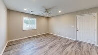 Located in Atlanta, GA, this single-floor 2-bedroom, 2-bathroom unit offers a practical and well-designed layout with consistent neutral tones and modern finishes throughout. The open kitchen features white cabinetry, granite-style countertops, a stainless steel sink, and black appliances including a refrigerator and range, with a window overlooking the entry that brings in natural light. The combined living area flows naturally from the kitchen, finished with the same wood-look laminate flooring found throughout the home. Both bedrooms are comfortably sized, featuring warm neutral walls, ceiling fans with light fixtures, and windows fitted with blinds that allow for natural light and outdoor views. The primary bedroom includes recessed lighting in addition to the ceiling fan, adding a layer of ambient versatility. Each bathroom is clean and functional, fitted with white vanity cabinetry, a single-basin sink, chrome fixtures, an oval mirror, and tile flooring. The overall design maintains a cohesive, minimalist aesthetic with white trim, six-panel doors, and light laminate flooring that runs consistently across the main living and bedroom spaces, creating a bright and unified feel throughout the unit.
