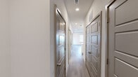 Located at 4233 Third Ave S in Birmingham, Alabama, this thoughtfully designed single-floor space combines modern finishes with a functional, open layout. The kitchen serves as a central highlight, showcasing crisp white cabinetry, granite countertops, a classic stone tile backsplash, and a full suite of stainless steel appliances including a refrigerator with ice maker, range, microwave, and dishwasher. A central island with matching granite provides additional prep space and is illuminated by a trio of pendant lights, creating a warm, inviting focal point. Light wood-tone flooring runs throughout the space, lending a cohesive and contemporary feel to every room. The living area is bright and open, featuring a ceiling fan with integrated lighting and a window fitted with blinds that allows natural light to fill the room. A well-appointed hallway lined with six-panel doors in a sophisticated gray tone connects the various rooms, offering excellent storage and privacy. The bathroom is finished with a granite-topped vanity, tile-surround soaking tub and shower combination, and coordinating wood-look flooring. Recessed lighting and visible HVAC vents throughout ensure comfort and functionality. The overall aesthetic is clean, modern, and move-in ready.