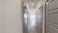 Located at 4233 Third Ave S in Birmingham, Alabama, this thoughtfully designed single-floor space combines modern finishes with a functional, open layout. The kitchen serves as a central highlight, showcasing crisp white cabinetry, granite countertops, a classic stone tile backsplash, and a full suite of stainless steel appliances including a refrigerator with ice maker, range, microwave, and dishwasher. A central island with matching granite provides additional prep space and is illuminated by a trio of pendant lights, creating a warm, inviting focal point. Light wood-tone flooring runs throughout the space, lending a cohesive and contemporary feel to every room. The living area is bright and open, featuring a ceiling fan with integrated lighting and a window fitted with blinds that allows natural light to fill the room. A well-appointed hallway lined with six-panel doors in a sophisticated gray tone connects the various rooms, offering excellent storage and privacy. The bathroom is finished with a granite-topped vanity, tile-surround soaking tub and shower combination, and coordinating wood-look flooring. Recessed lighting and visible HVAC vents throughout ensure comfort and functionality. The overall aesthetic is clean, modern, and move-in ready.