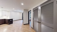 Located at 5820 Patterson Ave in Richmond, VA, this well-appointed one-bedroom, one-bathroom unit offers a thoughtfully designed single-floor layout with a clean, modern aesthetic. Light-toned hardwood-style flooring flows throughout the space, complemented by crisp white walls, dark baseboards, and charcoal-gray interior doors that lend a contemporary contrast.

The kitchen is a standout feature, showcasing a two-tone design with white upper cabinets and rich dark lower cabinetry, granite countertops, a subway tile backsplash, and a peninsula island ideal for casual dining or meal prep. Stainless steel appliances — including a French door refrigerator, electric range, over-the-range microwave, and dishwasher — complete the fully equipped space. Pendant lighting adds warmth above the peninsula.

The bedroom is a comfortable, well-proportioned retreat with a large window that invites natural light and a ceiling fan for year-round comfort. A dedicated closet with distinctive louvered double doors provides generous storage. The hallway connects all areas efficiently, maintaining an open and accessible flow.

The bathroom features tile flooring, a tub-shower combination, dark oil-rubbed bronze fixtures, a granite-topped vanity with dark cabinetry, and clean neutral walls. The overall design is modern, cohesive, and move-in ready.