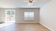 This two-story home in Springdale, Arkansas offers a well-designed layout with contemporary finishes throughout. The kitchen serves as a central highlight, showcasing white shaker-style cabinetry, speckled granite countertops, and a full suite of stainless steel appliances, including a range, microwave, refrigerator, and dishwasher. A center island with matching granite provides additional prep and casual dining space, while light wood-look flooring ties the area together with a clean, modern aesthetic.

The living areas feature the same light hardwood-style flooring, neutral gray walls, and ceiling fans, creating a bright and airy atmosphere. Bedrooms are finished with plush carpet and ceiling fans, offering a comfortable retreat. The primary bedroom suite connects to a spacious en-suite bathroom featuring a double-sink vanity with granite countertops, white cabinetry, and wood-look flooring. Secondary bedrooms include closets with built-in shelving for organized storage.

Bathrooms throughout maintain a consistent, polished look with granite counters and white cabinetry. The home also includes an attached two-car garage equipped with an automatic opener, providing convenient and secure parking.