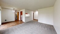 Located at 2332 Crestview Dr S in Salem, Oregon, this single-floor residence features two bedrooms and two bathrooms within a well-organized, efficient layout. The open living area is finished with plush carpet and a textured ceiling, with a ceiling fan adding to the comfort of the space. A pass-through window connects the living area to the kitchen, which is equipped with warm wood-toned cabinetry, a white refrigerator, and a range. Wood-look vinyl flooring runs through the kitchen and common areas, providing a cohesive and easy-to-maintain surface. Both bedrooms are carpeted and feature large sliding panel closets, offering generous storage. Natural light enters through windows with outdoor views of surrounding greenery, and baseboard heaters provide in-room climate control. The two bathrooms feature warm wood-toned vanities with light countertops, wood-look flooring, and a shower-tub combination. A dedicated in-unit laundry room includes washer and dryer hookups, built-in shelving, and wood-look flooring. A hallway connects the various rooms, contributing to the home's practical and straightforward flow throughout.