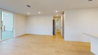 Located in the heart of Los Angeles, this modern 2-bedroom, 2-bathroom residence offers a thoughtfully designed open-concept layout with contemporary finishes throughout. Light wood flooring flows seamlessly across the spacious living, dining, and kitchen areas, which are bathed in natural light from large windows framing dynamic city views. The kitchen is a standout, featuring sleek walnut cabinetry, white lower cabinets, quartz countertops with a peninsula island, and a full suite of stainless steel appliances. The open layout connects the kitchen naturally to the dining and living areas, creating an ideal space for entertaining. Both bedrooms are generously proportioned with clean lines, recessed lighting, and ample closet space — four closets in total serve the unit. The bathrooms are elegantly finished with floor-to-ceiling marble-style tile, a combination soaking tub and shower enclosed in frameless glass, and warm wood vanities with stone countertops. A private balcony extends the living space outdoors, offering sweeping panoramic views of the Los Angeles skyline. Additional conveniences include an in-unit laundry area and a well-connected hallway layout. This residence combines modern urban design with practical functionality in a prime LA location.