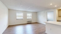 Located at 210 Senate Ave in Camp Hill, PA, this two-bedroom, two-bathroom residence offers a thoughtfully arranged single-floor layout. The open-concept kitchen and living area serves as the heart of the home, featuring light hardwood-style flooring, white subway tile backsplash, gray shaker-style cabinetry with modern hardware, white quartz countertops, a stainless steel sink, and a dishwasher. Natural light filters through multiple windows fitted with blinds, creating a bright and welcoming atmosphere throughout.

The living area is generously proportioned, with clean white walls and a neutral palette that lends itself to a variety of décor styles. A hallway connects the common areas to the private spaces, with an impressive five closets distributed across the unit for ample storage.

The primary bedroom is carpeted and well-sized, featuring a double-door closet and a window with outdoor views. The second bedroom also offers plush carpeting and natural light. Each of the two bathrooms is finished with hardwood-style flooring; one includes a tub/shower combo with gray vanity cabinetry, while the second features a walk-in shower and a light blue vanity. A dedicated laundry area rounds out this practical and well-appointed home.