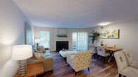 This single-floor residence offers a thoughtfully designed layout that balances comfort and functionality throughout. The open-concept living and dining area serves as the heart of the home, showcasing rich hardwood-style flooring, neutral walls, and generous natural light from multiple windows and sliding glass doors that lead to an outdoor balcony. A fireplace anchors the living space, adding warmth and character, while the adjacent dining area provides an inviting setting for everyday meals or entertaining.

The kitchen is equipped with warm wood cabinetry, granite-style countertops, stainless steel appliances including a range, microwave, and refrigerator, and a classic subway tile backsplash. A built-in pantry adds practical storage.

The bedroom is a serene retreat, featuring plush carpeting, dual windows that fill the room with natural light, and a ceiling fan for year-round comfort. The room offers ample space for furnishings and includes convenient closet access.

Two full bathrooms mirror each other in style, each featuring warm wood vanities, granite-topped counters, framed mirrors, and tiled shower-tub combinations with hardwood-style flooring. The overall ambiance throughout the residence is clean, bright, and move-in ready.