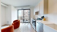 Located at 310 N Second St in Minneapolis's vibrant North Loop neighborhood, this efficiently designed one-bedroom, one-bathroom unit offers a thoughtful layout across a single floor. A wide entry hallway with track lighting and light wood-tone flooring leads into the open living and kitchen area, which is anchored by a large floor-to-ceiling window and sliding glass door that opens to a private balcony overlooking the surrounding cityscape, flooding the space with natural light.

The kitchen is well-appointed with white cabinetry, a classic subway tile backsplash, stainless steel appliances including an electric range and dishwasher, and a deep farmhouse-style sink. Light countertops and ample cabinet storage maximize functionality within the compact footprint.

The bedroom is a cozy, private retreat with clean white walls and warm hardwood flooring, offering a calm atmosphere ideal for rest. The bathroom continues the modern aesthetic with white subway tile surrounding the tub-shower combo, matte black fixtures, a white vanity, and hardwood-style flooring that adds warmth to the crisp, clean design.

Throughout the unit, white walls, light flooring, and black hardware accents create a cohesive, contemporary feel well-suited to urban living in one of Minneapolis's most walkable neighborhoods.