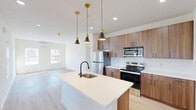 Located at 365 Ridge Rd in Dayton, NJ, this thoughtfully designed single-floor home offers four bedrooms and three bathrooms with a clean, modern aesthetic throughout. The open kitchen is a standout feature, showcasing warm wood cabinetry with matte black hardware, quartz countertops, stainless steel appliances including a refrigerator, range, and built-in microwave, and a peninsula with an undermount sink and pendant lighting. Light wood-look flooring runs seamlessly through the main living areas and bedrooms, complementing the crisp white walls and creating a bright, airy atmosphere. The living room is generously sized, bathed in natural light from multiple windows that offer views of the surrounding neighborhood. Each bedroom is well-proportioned, with the primary bedroom providing a comfortable retreat. The bathrooms are finished in a contemporary style, featuring large-format marble-look tile flooring, floating wood vanities with white countertops, matte black fixtures, and clean white walls. Wall-mounted mini-split units provide climate control throughout the home. The overall design emphasizes simplicity and functionality, making this a well-appointed home in a convenient New Jersey location.