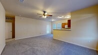 Located at 513 Dodson Rd in Rogers, Arkansas, this single-floor home offers a practical and comfortable layout designed for everyday living. The spacious living area is finished with plush carpeting and features a ceiling fan with light fixture, creating a comfortable atmosphere throughout. Natural light filters in through windows and a glass-paneled exterior door, adding brightness to the open space.

The kitchen is well-equipped with warm wood cabinetry, tile flooring, light countertops, and a full suite of white appliances including an electric range, over-the-range microwave, refrigerator, and dishwasher. A pass-through bar connects the kitchen to the living area, making it ideal for casual dining and entertaining.

The bedrooms are carpeted and generously sized, each outfitted with ceiling fans and windows that allow for natural light. One bedroom includes access to a walk-in closet with wire shelving, providing ample storage. The bathroom is well-appointed with a single vanity featuring wood cabinetry, a large mirror, tile flooring, and a full tub-shower combo with tiled surround.

A dedicated laundry area accommodates a full-size washer, with an overhead wire shelf for added utility. The home's neutral color palette and functional design make it a versatile and move-in ready space.