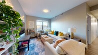 Located at 17 E Lane Ave in Columbus, OH, this single-floor unit offers three bedrooms, three full bathrooms, and a thoughtfully designed open-concept layout. The combined kitchen and living area serves as the heart of the home, featuring hardwood-style flooring, large windows that welcome abundant natural light, and views of the surrounding neighborhood. The kitchen is outfitted with stainless steel appliances including a range, microwave, and French door refrigerator, complemented by taupe wood cabinetry and a granite-topped island with bar seating and pendant lighting above — ideal for dining or casual entertaining. The living area flows seamlessly from the kitchen, providing a comfortable gathering space with room for multiple seating arrangements. Each of the three bedrooms offers carpeted flooring and a window for natural light, with the cozy scale of each room lending an intimate feel. Four closets are distributed throughout the unit for ample storage. The three full bathrooms feature hardwood-style flooring, vanities with wood cabinetry and white countertops, and shower-tub combinations. A dedicated laundry area and utility room add everyday convenience. A connecting hallway ties the layout together efficiently, making this a well-organized and functional home.