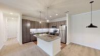 Located at 8344 Frank Houser Ave in Columbus, Georgia, this single-story home offers a well-designed layout across four bedrooms and two bathrooms. The kitchen serves as a central highlight, showcasing rich dark-toned cabinetry, a white subway tile backsplash, stainless steel appliances, and a granite-topped center island illuminated by stylish pendant lighting. Recessed lighting and crown molding add a polished finish, while wood-style flooring grounds the space before transitioning to plush carpet in the living and bedroom areas.

The open-concept design connects the kitchen seamlessly to the living area, creating a cohesive and functional gathering space. The bedrooms are carpeted and bright, with clean white walls and recessed lighting. The primary bedroom is generously sized and features direct access to a closet. Additional bedrooms also offer closet space, including one with a distinctive sliding barn door. Two hallways connect the rooms efficiently throughout the home.

The bathrooms are finished with granite-topped vanities, dark cabinetry, wood-look flooring, and tub-shower combinations. A walk-in closet with wire shelving provides practical storage. Overall, the home presents a clean, modern aesthetic with consistent finishes throughout.