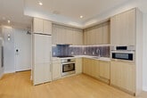 Located at 1224 M St NW in the heart of Washington, DC, this thoughtfully designed one-bedroom, one-bathroom residence offers a clean, modern aesthetic throughout. Light hardwood flooring flows seamlessly across the entire unit, complementing the crisp white walls and recessed lighting that give every room a bright, airy feel.

The open-concept living and dining area is anchored by expansive floor-to-ceiling windows and sliding glass doors that lead to a private balcony, flooding the space with natural light and offering views of the surrounding cityscape. The well-appointed kitchen features flat-front light wood cabinetry extending to the ceiling, white quartz countertops, a stylish gray subway tile backsplash, and a full suite of stainless steel Bosch appliances, including a gas range, wall oven, built-in microwave, and dishwasher.

The bedroom is generously sized with large windows that continue the home's emphasis on natural light. The bathroom is finished with large-format marble-look porcelain tile flooring, a floating wood vanity with a backlit mirror, and a full soaking tub with tiled surround. Additional conveniences include in-unit laundry, two closets, and a dedicated entrance hallway, making this a well-rounded and functional urban residence.