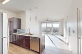 This thoughtfully designed one-bedroom, two-bathroom unit in Council Bluffs, Iowa offers a clean, modern aesthetic throughout. The open-concept kitchen and living area serves as the heart of the home, featuring light hardwood-style flooring, rich dark-wood cabinetry, a peninsula with a stainless steel sink and dishwasher, stainless steel refrigerator, and pendant lighting overhead. The living area flows naturally toward large sliding glass doors that open to a private balcony, flooding the space with abundant natural light and offering pleasant outdoor views. A ceiling fan adds to the comfort of the living space. The bedroom is a well-proportioned retreat finished with plush carpet, a ceiling fan, and a large window that continues to bring in natural light and exterior views. Three closets provide generous storage, including a walk-in closet with multi-tier wire shelving for organized storage. Both bathrooms are clean and functional, with one featuring a walk-in shower with grab bars and light wood-tone flooring. A dedicated in-unit laundry area houses a full-size washer and dryer. The overall ambiance is bright, airy, and contemporary, making efficient use of every square foot in a well-planned layout.