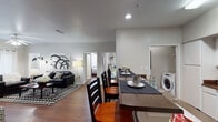 This well-appointed 4-bedroom, 4-bathroom single-story residence offers a thoughtfully designed open-concept layout that seamlessly connects the main living areas. Rich hardwood flooring flows throughout, lending warmth and continuity to the entire space.

The kitchen is equipped with stainless steel appliances, including a refrigerator and microwave, white cabinetry, and a peninsula with bar seating — ideal for casual dining or entertaining. Adjacent to the kitchen, a dedicated dining area features pendant lighting and ample room for a full dining table. An in-unit washer is conveniently located nearby, adding functional ease to daily living.

The living room is bright and inviting, with a ceiling fan, large windows that usher in natural light, and access to an exterior door. The open sightlines between the living, dining, and kitchen areas create a cohesive and social atmosphere.

Each of the four bedrooms offers hardwood floors, ceiling fans, and large windows with vertical blinds providing privacy and natural light. Select bedrooms include built-in desks and closet access, making them well-suited for both rest and productivity.

The four bathrooms are clean and functional, each featuring a vanity with storage, mirror, and shower/tub combination. The neutral color palette throughout the residence creates a calm, versatile backdrop adaptable to a variety of living arrangements.