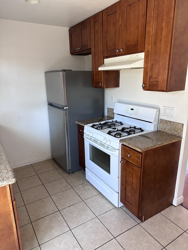 Kitchen with gas stove and refrigerator - 1784 River Dr