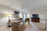 Located at 200 Trotter Rd in Weymouth, MA, this well-appointed one-bedroom, one-bathroom residence offers a thoughtfully designed layout across a single floor. The open-concept living and kitchen area serves as the heart of the home, where warm-toned carpet and tile flooring complement neutral walls accented by crown molding. The living room features a ceiling fan, ample natural light from large windows, and an airy atmosphere ideal for both relaxing and entertaining. The kitchen is outfitted with rich wood cabinetry, dark granite countertops, stainless steel appliances including a range and refrigerator, and hardwood-style flooring that transitions seamlessly from the cooking space to the main living area. Pendant lighting over the kitchen peninsula adds a stylish finishing touch. The bedroom is a comfortable retreat with dual windows that invite natural light and views of the surrounding neighborhood. The bathroom includes a tub-shower combination and wood-toned cabinetry for additional storage. A dedicated in-unit laundry room with shelving adds everyday convenience. Three closets throughout the residence provide generous storage. Crown molding and ceiling fans appear consistently across rooms, lending a cohesive, polished character to the entire home.
