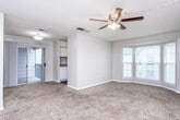 Located at 1910 Honeysuckle Rd in Dothan, Alabama, this single-story residence offers a straightforward and functional layout designed for comfortable everyday living. The main living area is generously sized, featuring warm neutral-toned carpet, a ceiling fan with light fixture, and a large bay-style window that invites natural light into the space. The open sightline connects the living area to the kitchen, which is equipped with white cabinetry, speckled laminate countertops, a stainless steel sink, a dishwasher, and a full-size refrigerator — offering practical storage and prep space. The bedrooms are well-proportioned, each featuring plush carpeting, textured ceilings, and access to closet space, including what appears to be a walk-in closet in one of the rooms. The bathroom includes a single-sink vanity with white cabinetry, a mirror, and a shower/tub combination, with wood-look vinyl flooring extending into the hallway for a clean transition between spaces. Throughout the home, neutral wall tones and consistent finishes create a cohesive and move-in ready environment. Ceiling fans are present in multiple rooms, adding to the home's practical comfort features.