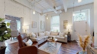 Located at 809 Chattanooga Ave in Dalton, Georgia, this two-floor space masterfully combines historic industrial character with modern comfort. Throughout the interior, rich hardwood floors, soaring ceilings with whitewashed wood planking, and exposed ductwork and beams create a distinctive loft-style atmosphere.

The living area is anchored by whitewashed brick walls and tall ceilings that amplify the sense of openness. Natural light pours in through large windows fitted with blinds, illuminating the space warmly alongside pendant lighting. The dining area continues the exposed brick aesthetic, with floor-to-ceiling brick walls and generous windows framing views of the surrounding greenery.

The kitchen is outfitted with dark cabinetry, stainless steel appliances including a range, microwave, and dishwasher, and offers efficient, well-organized functionality. The bedroom features a striking accent wall of raw exposed brick, soaring ceilings with a ceiling fan, sheer curtains filtering soft natural light, and ample storage. The bathroom includes dark cabinetry paired with hardwood flooring, maintaining the cohesive design language found throughout.

Overall, this space delivers a compelling blend of historic architectural detail and contemporary livability in the heart of Dalton, GA.