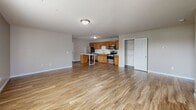 This single-floor residence offers a practical and comfortable layout designed for everyday living. The open-concept main area seamlessly connects the kitchen and living space, creating a generous, airy feel throughout. The kitchen is well-equipped with warm honey-toned cabinetry, stainless steel appliances including a refrigerator, electric range, microwave, and dishwasher, along with light countertops and a double-basin sink. A peninsula island provides additional prep space and casual seating. Light-toned hardwood-style flooring runs throughout the main living areas, complementing the neutral color palette on the walls and ceilings.

The living area is spacious and bright, benefiting from natural light through windows that offer views to the outdoors. Bedrooms are well-sized with large windows and include dedicated closet space with built-in shelving for ample storage. The two full bathrooms each feature a tub-shower combination with clean white surrounds and marble-look tile flooring. A dedicated laundry closet houses a stacked washer and dryer unit for added convenience. Textured ceilings add a classic touch throughout the home, while the clean, neutral finishes create a move-in-ready environment.