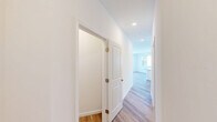 Located at 112 Garden St in South Burlington, Vermont, this thoughtfully designed two-bedroom, two-bathroom residence offers a bright and modern living experience across a single floor. The open-concept kitchen and living area serves as the heart of the home, featuring white shaker cabinetry, stainless steel appliances, a central island with a built-in sink, and light wood-tone flooring that flows seamlessly throughout the space. Large windows flood the kitchen and living area with natural light while offering views of the surrounding neighborhood and greenery. The two bedrooms are well-proportioned, with the spacious primary bedroom offering ample room to accommodate a full furniture arrangement. Both bedrooms feature light hardwood-style flooring, recessed lighting, and windows that bring in natural light. The two bathrooms are finished in a clean, neutral palette — one featuring a full tub-shower combination with chrome fixtures and a white vanity, and the other offering a bright, accessible layout with tile flooring, a single vanity, and grab bars. A mini-split system provides climate control in the living area, complemented by baseboard heating throughout. The consistent use of white walls, light flooring, and modern fixtures gives the entire residence a fresh, move-in-ready ambiance.