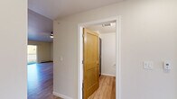 Located at 3900 Woodland Rd in Howard, Wisconsin, this 2-bedroom, 1-bathroom unit offers a well-organized, single-floor layout designed for comfortable everyday living. The open-concept kitchen and living area serves as the heart of the home, featuring light hardwood-style flooring throughout. The kitchen is equipped with stainless steel appliances — including a range, over-the-range microwave, and refrigerator — complemented by warm wood cabinetry with ample upper and lower storage, white countertops, and a navy blue island with pendant lighting above, adding a stylish focal point to the space. A sliding glass door leads to a private balcony, filling the living area with natural light. The primary bedroom is generously sized, carpeted for comfort, and includes a walk-in closet with built-in shelving. The second bedroom also features plush carpet, a ceiling fan with light fixture, and a window with a neighborhood view. The bathroom is finished with light hardwood-style flooring, a dark-toned vanity with a white countertop, a large mirror, and chrome fixtures. Two-panel wood interior doors and baseboard heating appear consistently throughout, lending a cohesive, clean aesthetic to the entire unit.