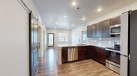 Located at 15329 Monument Ridge Ct in Monument, Colorado, this well-appointed 2-bedroom, 3-bathroom residence offers a thoughtfully designed single-floor layout. The kitchen is a standout, featuring rich dark cabinetry, granite countertops, a tile backsplash, stainless steel appliances including a refrigerator, range, and microwave, and a large peninsula island ideal for dining or meal prep. A distinctive sliding barn door adds a modern touch to the space. Wood-style plank flooring flows throughout the main living and kitchen areas, lending warmth and continuity. Each bedroom is carpeted and equipped with a ceiling fan, with windows that bring in natural light. The primary bedroom includes access to a dedicated bathroom featuring a granite-topped dark vanity, a soaking tub with tiled surround, and wood-style flooring. A walk-in closet with wire shelving system provides ample storage. The additional bathrooms mirror the quality finishes found throughout, including matching vanities and tub-shower combinations. A dedicated water closet offers added privacy and convenience. The overall aesthetic is clean and contemporary, with neutral tones and quality finishes creating a cohesive, move-in-ready environment.
