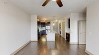 Located at 4670 Amesbury Dr in Dallas, TX 75206, this one-bedroom, one-bathroom residence offers a thoughtfully designed open-concept layout with modern finishes throughout. Rich hardwood flooring flows through the main living area, anchored by a ceiling fan and abundant natural light from large windows and a glass-paneled door leading to an outdoor area.

The kitchen is a standout feature, showcasing dark espresso cabinetry, a teal subway tile backsplash, stainless steel appliances — including a refrigerator, electric range, and microwave — and a generous granite-topped island with an undermount sink, dishwasher, and pendant lighting above. Track lighting illuminates the full kitchen, which offers ample storage with floor-to-ceiling cabinetry.

The bedroom is a quiet retreat with plush carpet flooring and access to a well-organized walk-in closet fitted with multiple hanging rods and shelving. The bathroom features large-format tile flooring, a soaking tub with tiled surround, and a dark-cabinetry vanity topped with granite. A dedicated laundry closet with full hookups adds everyday convenience. The space offers a clean, contemporary aesthetic ideal for comfortable urban living.
