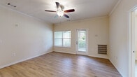 This well-designed three-bedroom, two-bathroom home in Duncan, SC offers comfortable single-floor living across a thoughtfully laid-out floor plan. The inviting living room serves as the heart of the home, featuring light hardwood-style flooring, crown molding, a ceiling fan, and large windows that fill the space with natural light. A glass-paned door leads out to a private outdoor area, adding a seamless indoor-outdoor connection. The kitchen is both functional and stylish, offering warm honey-toned cabinetry, dark granite-style countertops, a double-basin sink, and black appliances including a range and built-in microwave, all illuminated by track lighting overhead. The primary bedroom is generously sized, with a natural light-filled window and access to a spacious walk-in closet featuring built-in wire shelving on multiple walls. The additional bedrooms also offer hardwood-style flooring and ample natural light. The bathrooms are finished with wood-toned vanity cabinetry and light countertops. A dedicated laundry room includes washer and dryer hookups, overhead shelving, and a dryer exhaust connection. Throughout the home, neutral tones, consistent flooring, and clean finishes create a bright and cohesive atmosphere.
