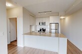 Located at 2550 Eglinton Avenue West in Mississauga, this efficiently designed one-bedroom, one-bathroom unit offers a thoughtfully organized layout across a single floor. The open-concept kitchen and living area forms the heart of the space, featuring a sleek peninsula with a stone-look countertop, an undermount sink, and a suite of stainless steel appliances including a range, built-in microwave, refrigerator, and dishwasher. Crisp white cabinetry with ample storage and a subway tile backsplash complete the modern kitchen aesthetic, while track lighting overhead adds a polished touch. Warm wood-look flooring flows throughout, creating a cohesive and inviting atmosphere. The living area benefits from floor-to-ceiling sliding glass doors that open onto a private balcony, filling the space with abundant natural light and offering expansive views of the surrounding Mississauga cityscape and greenery. The bedroom is a calm, neutral retreat with its own access to the balcony and generous wall space. A dedicated closet provides organized storage. The bathroom is finished with large-format tile flooring, a white vanity with a mirror, subway tile accents, and a separate shower enclosure, maintaining the clean, contemporary feel found throughout the entire unit.