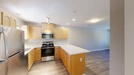 Located at 2002 Cedar Fork Dr in Greensboro, NC, this single-floor, one-bedroom, one-bathroom home offers a well-designed layout that makes efficient use of its space. The open-concept kitchen flows naturally into the living area, creating a cohesive and functional common space. The kitchen is equipped with stainless steel appliances — including a range, over-the-range microwave, and refrigerator — complemented by warm-toned maple cabinetry, clean white countertops, and a peninsula that provides additional prep and serving space. Recessed lighting and a track light fixture keep the kitchen well-lit throughout the day. Wood-look flooring runs consistently throughout the home, adding warmth and visual continuity. The living area is bright and open, featuring a ceiling fan and windows with blinds that allow for natural light. The bedroom is a comfortable size, fitted with its own ceiling fan, a window overlooking the outdoors, and access to two closets — including a spacious walk-in closet outfitted with wire shelving systems for organized storage. The bathroom features wood-look tile flooring, a tub-shower combination, and clean, neutral finishes. Neutral wall tones and crisp white trim throughout the home create a calm, move-in-ready aesthetic.