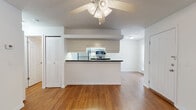 Located at 4455 SW 34th St in Gainesville, FL, this single-floor residence offers a well-designed, open-concept layout that maximizes functionality and flow. The living area features warm hardwood-style flooring and a ceiling fan with integrated lighting, creating a comfortable and airy atmosphere. A peninsula-style kitchen anchors the heart of the home, showcasing dark granite countertops, white cabinetry, and a full suite of stainless steel appliances including a refrigerator, electric range, and built-in microwave. The kitchen opens directly to the living space, making it ideal for everyday living and entertaining. A hallway with a louvered closet door connects the common areas to the private spaces. The bedrooms are carpeted for added comfort and each features a ceiling fan, ample wall space, and easy access to adjacent closet storage. The bathroom is clean and functional, outfitted with a tub-shower combination, wood-look flooring, and a vanity topped with dark granite that mirrors the kitchen's finishes, providing a cohesive aesthetic throughout. Neutral white walls and consistent finishes across the unit contribute to a bright, move-in-ready environment suitable for a variety of lifestyles.