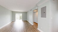 Located at 6742 Gulfport Blvd S in South Pasadena, Florida, this one-bedroom, one-bathroom residence offers a thoughtfully designed layout across a single floor. Light wood-style flooring runs throughout the space, complemented by soft sage-green walls and bright white trim, creating a clean, coastal aesthetic.

The open-concept kitchen and living area form the heart of the home. The kitchen is well-appointed with stainless steel appliances — including a range, microwave, dishwasher, and refrigerator — paired with taupe shaker-style cabinetry, light quartz countertops, a double sink, a wine rack, and a soft blue-green subway tile backsplash. A ceiling fan in the living area and abundant natural light from windows with plantation-style blinds enhance the airy feel.

The bedroom is a comfortable, well-proportioned room featuring a ceiling fan, a dedicated closet with built-in shelving, and a window that brings in natural light. A sliding glass door leads directly to a private balcony, offering outdoor access and views of the surrounding greenery.

The bathroom features a full soaking tub and shower with white subway tile surround, accented by a decorative mosaic border in neutral and coastal tones. A hallway connects the key areas of the home, completing this well-organized and stylishly updated residence.