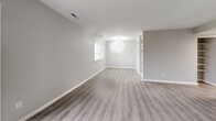 Located at 134 Graham Rd in Lansing, NY, this two-bedroom, one-bathroom unit offers a well-designed single-floor layout with modern updates throughout. The open living room is bright and welcoming, featuring light gray luxury vinyl plank flooring, neutral gray walls, and large sliding glass doors that lead to a private balcony overlooking a lush, open green lawn with pleasant views of the surrounding landscape. The kitchen is thoughtfully appointed with granite-patterned countertops, warm wood lower cabinetry, glossy white upper cabinets with black hardware, a stainless steel sink with a matte black faucet, and marble-look tile flooring. The spacious primary bedroom provides a comfortable retreat with natural light from a large window and the same LVP flooring found throughout the unit. The second bedroom is similarly finished, offering a bright and clean space with its own window. The bathroom features marble-look tile flooring, clean white walls, and a shower-tub combination. A connecting hallway ties the layout together efficiently. The unit's consistent neutral palette, updated materials, and private outdoor access make it a clean, functional, and comfortable living space in a well-maintained community setting.