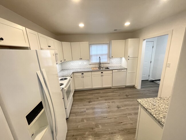 The granite counter tops shine under brand new can lighting. - 14553 Old Courthouse Way