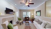 This single-floor residence in Germantown, Tennessee offers a thoughtfully designed layout featuring two bedrooms and two full bathrooms. The living room serves as the heart of the home, showcasing rich hardwood flooring, crown molding, a textured ceiling with a ceiling fan, and a classic fireplace with a decorative white mantel and tile surround. Multiple windows allow natural light to fill the space, creating a warm and inviting atmosphere.

The kitchen is well-equipped with stainless steel appliances, including a refrigerator and electric range, complemented by white cabinetry, granite countertops, and hardwood flooring — offering both style and functionality.

The primary bedroom features plush carpeting, neutral tones, and a serene ambiance with room for generous furnishings. The second bedroom is equally comfortable, with carpeted floors, a ceiling fan, and windows that overlook the greenery outside.

Both bathrooms are clean and functional, each featuring a tub-shower combination with a curved curtain rod, hardwood-style flooring, and ample storage with white cabinetry. One bathroom includes a granite-topped vanity for added elegance.

Throughout the residence, warm neutral wall tones, consistent finishes, and plentiful natural light contribute to a cohesive and comfortable living environment.