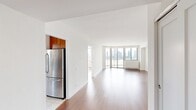 This contemporary apartment, located at 401 E 34th St in Manhattan, offers 930 square feet of thoughtfully designed living space. The open-concept layout showcases gleaming hardwood floors throughout, creating a seamless flow between rooms. The living area is generously proportioned, with pristine white walls that reflect natural light from large windows.

The highlight of the apartment is a stunning curved window bay, providing panoramic views of the New York City skyline. This architectural feature floods the space with sunlight and serves as a focal point for the living area.

The kitchen is a chef's delight, featuring honey-toned wood cabinetry, sleek black granite countertops, and stainless steel appliances. Tile flooring in the kitchen area offers easy maintenance and complements the overall design aesthetic.

Two bedrooms provide ample private space, with the primary bedroom boasting 200 square feet. Both bathrooms are well-appointed, featuring clean lines and neutral tones. One bathroom showcases a combination tub/shower with beige tiled walls, while the other offers a modern walk-in shower.

Storage is plentiful throughout the apartment, with built-in closets and cabinetry. The property's single-floor layout ensures ease of access and movement. This meticulously maintained apartment combines style and functionality, offering a turnkey urban living experience in the heart of New York City.