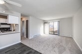 This single-floor unit offers a clean, functional layout designed for comfortable everyday living. The open-concept living and dining area is finished with plush carpeting and features a ceiling fan, a textured ceiling, and a sliding glass door that opens to a private balcony, filling the space with natural light and providing outdoor views. A wall-mounted AC unit and baseboard heating ensure year-round comfort.

The galley-style kitchen is thoughtfully updated with crisp white cabinetry, granite-look countertops, a stainless steel sink, and black appliances including a refrigerator and electric range. Wood-look tile flooring runs throughout the kitchen, adding a modern contrast to the carpeted living spaces. A breakfast bar pass-through connects the kitchen to the main living area, enhancing the open feel.

The bedrooms are generously sized, each featuring soft carpet, neutral walls, and ample natural light from windows with blinds. One bedroom includes a ceiling fan and direct access to the bathroom, providing added convenience. The bathroom is equipped with a full tub-and-shower combo, a vanity with storage, and tile flooring. Throughout the unit, a neutral color palette and consistent finishes create a cohesive, move-in-ready atmosphere.