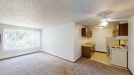 Located at 1325 Atlas St in Rapid City, South Dakota, this 2-bedroom, 1-bathroom unit offers a functional single-floor layout. The combined kitchen and living room forms the heart of the home, where the living area features wall-to-wall carpeting, a ceiling fan, a large window with vertical blinds, and a baseboard heating system. The kitchen transitions seamlessly from the living space and is equipped with dark wood cabinetry on both sides, a double-basin sink with light-toned countertops, a white electric range, a refrigerator, and tile flooring.

Both bedrooms are carpeted and bright, each benefiting from natural light through windows overlooking greenery. The primary bedroom offers a spacious feel and features a sliding-door closet with built-in shelving, while the second bedroom also includes closet storage. Textured popcorn ceilings are consistent throughout the unit.

The bathroom is clean and efficiently designed, featuring a shower-tub combination, a wall-mounted pedestal sink, a toilet, tile flooring, and a wood-framed medicine cabinet with overhead lighting. A hallway connects the private and shared areas of the unit, completing the practical and straightforward floor plan.