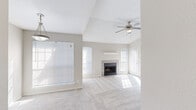 Located at 9939 Quail Blvd in Austin, TX, this single-floor, one-bedroom unit offers a thoughtfully arranged layout that maximizes its footprint. The open living room immediately impresses with soaring vaulted ceilings and a ceiling fan, creating an airy, spacious feel. A tile-surround fireplace anchors the main wall, flanked by windows that flood the room with natural light. Soft, neutral-toned carpet runs throughout the living areas and bedroom, complementing the warm, understated color palette of the walls.

The kitchen connects seamlessly to the living space via a pass-through counter with granite countertops, rich dark-wood cabinetry, stainless steel appliances including an over-the-range microwave, and a decorative mosaic tile backsplash. Hardwood flooring in the kitchen adds a warm contrast to the carpeted living areas.

The bedroom is generously sized, featuring a ceiling fan, large sliding glass door with vertical blinds that invite natural light, and access to a dedicated closet. The overall ambiance throughout the unit is clean, bright, and neutral, offering a versatile canvas well-suited for a variety of interior styles.