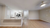 This contemporary apartment in Raleigh, NC offers a well-designed living space of 990 square feet. The layout includes two bedrooms and two bathrooms, with the primary bedroom boasting a generous 230 square feet. The heart of the home is an open-concept kitchen and living area, featuring sleek white cabinetry, stainless steel appliances, and a functional island that doubles as a breakfast bar. The kitchen's light-colored wood-look flooring extends into the living space, creating a seamless flow and enhancing the sense of openness.

Both bathrooms are equipped with modern fixtures, including a combination tub and shower with white tiled surrounds. The bedrooms are carpeted for comfort, with the primary bedroom offering ample space and natural light through large windows. Crown molding throughout adds a touch of elegance to the neutral-toned walls.

The living area is brightened by a sliding glass door leading to an outdoor space, allowing for natural light and fresh air. Ceiling fans in the bedrooms and living area provide additional comfort. The apartment also includes a utility room for added convenience. Overall, this apartment combines functionality with modern aesthetics, offering a comfortable and stylish living environment in a prime Raleigh location.