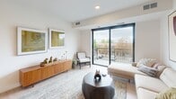 Located at 393 Marshall Ave in Saint Paul, Minnesota, this contemporary single-floor residence offers a thoughtfully designed open layout with clean lines and modern finishes throughout. The living area is a standout space, flooded with natural light through large, black-framed floor-to-ceiling sliding glass doors that open onto a private balcony overlooking the surrounding neighborhood. Light wood-tone flooring anchors the space, complementing the neutral palette and creating a warm, cohesive ambiance.

The kitchen is well-appointed with white cabinetry accented by black hardware, dark countertops, a subway tile backsplash, and a full suite of stainless steel appliances, including a refrigerator, dishwasher, built-in microwave, and range. Recessed lighting and ample cabinet storage make this a highly functional cooking space.

The bedrooms feature plush carpeting and bold black-framed windows that frame neighborhood views and invite generous natural light. Closet space is provided via full double-door built-in closets. The bathrooms are finished in a clean, minimalist style with light wood-tone flooring, white vanities, and tub-shower combinations. The overall design of the residence balances modern aesthetics with practical comfort.