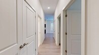 Located at 610 S 29th St in Louisville, KY, this single-story unit offers a practical and well-organized floor plan across three bedrooms, two bathrooms, and a generous overall footprint. Light wood-style flooring runs throughout the main living areas, hallways, and bedrooms, lending a cohesive and contemporary feel to the interior. The open living room is bright and airy, featuring a ceiling fan, neutral walls, and a set of double doors with transom windows that allow natural light to fill the space. Adjacent to the living area, the kitchen is equipped with dark cabinetry, light countertops, and black appliances including a refrigerator and dishwasher, creating a functional contrast to the lighter surroundings. A central hallway connects the bedrooms and bathrooms, lined with multiple closets offering ample storage throughout. Each bedroom features light flooring, neutral painted walls, and windows fitted with horizontal blinds for natural light and privacy. The spacious primary bedroom provides a comfortable retreat. Both bathrooms are finished with tile flooring and include a full tub-shower combination with brushed nickel fixtures. A dedicated laundry area adds everyday convenience, completing this clean and efficiently designed home.
