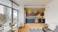 Located at 206 Bell St, Unit 507 in Seattle's Belltown neighborhood, this one-bedroom, one-bathroom residence offers a well-designed urban living experience. The open-concept layout seamlessly connects the kitchen, dining, and living areas, creating a functional and cohesive space. Light hardwood flooring flows throughout the main living areas, adding warmth and continuity.

The kitchen is outfitted with sleek dark wood cabinetry, granite-style countertops, stainless steel appliances including a range, dishwasher, and microwave, and a wall-mounted range hood — combining both style and practicality. The living and dining area benefits from large floor-to-ceiling windows that frame impressive city skyline views and fill the space with natural light.

The bedroom features plush carpeting, generous windows with city views, and access via a sliding glass door, providing a quiet retreat. A dedicated closet adds storage convenience. The combined bathroom and laundry room includes tile flooring, a granite-topped vanity, grab bar, and in-unit washer, all served by a window for natural ventilation. A private balcony extends the living space outdoors, perfect for taking in Seattle's urban scenery.