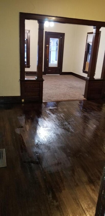 Standing in the extra living space (which could be used as an office or dining room), the photographer is facing the entry door which leads you into the living room which has brand new carpet and paint. - 215 N 19th St